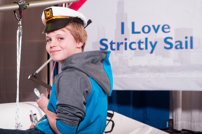 cute little boy poses at strictly sail chicago tradeshow photo booth, onsite photo printing and social media sharing by fab photo chicago.