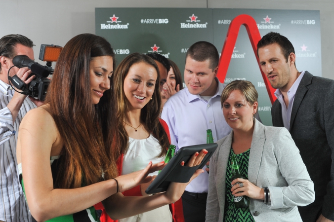 trade show model helps guest send photo to social media at heineken corporate event